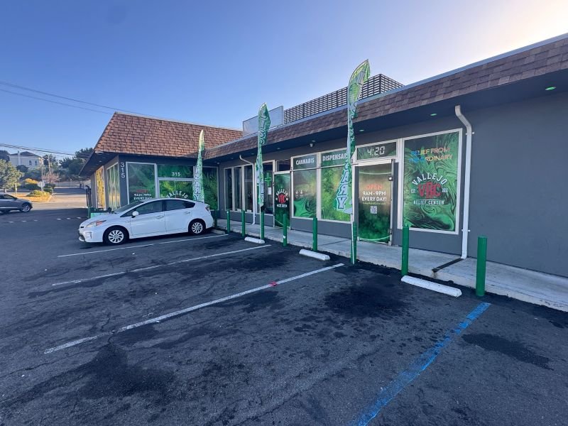 Front view of Vallejo Relief Center dispensary on Springs Road with parking spaces and green cannabis signage.