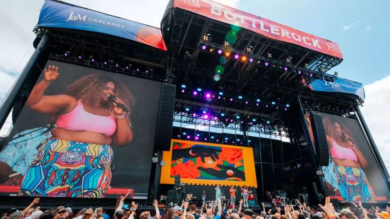 Singer performing on the main stage at BottleRock Napa Valley music festival with large video screens and cheering crowd.