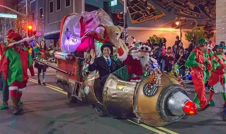 Santa and performers riding a whimsical holiday float during the Mad Hatter Holiday Festival parade in Vallejo.