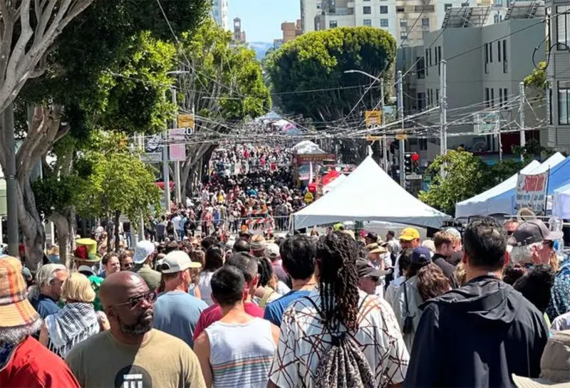 Street packed with people, food vendors, and live music during the Fillmore Jazz Festival in San Francisco.