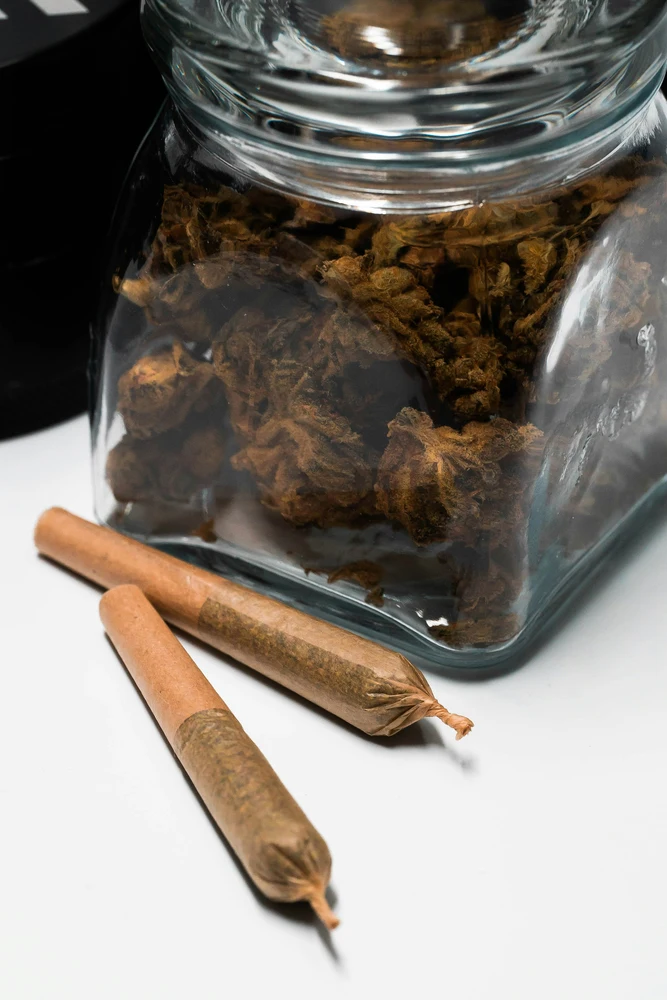 pre-rolls and a jar of cannabis flower on a white table as a part of knowing what is dab day
